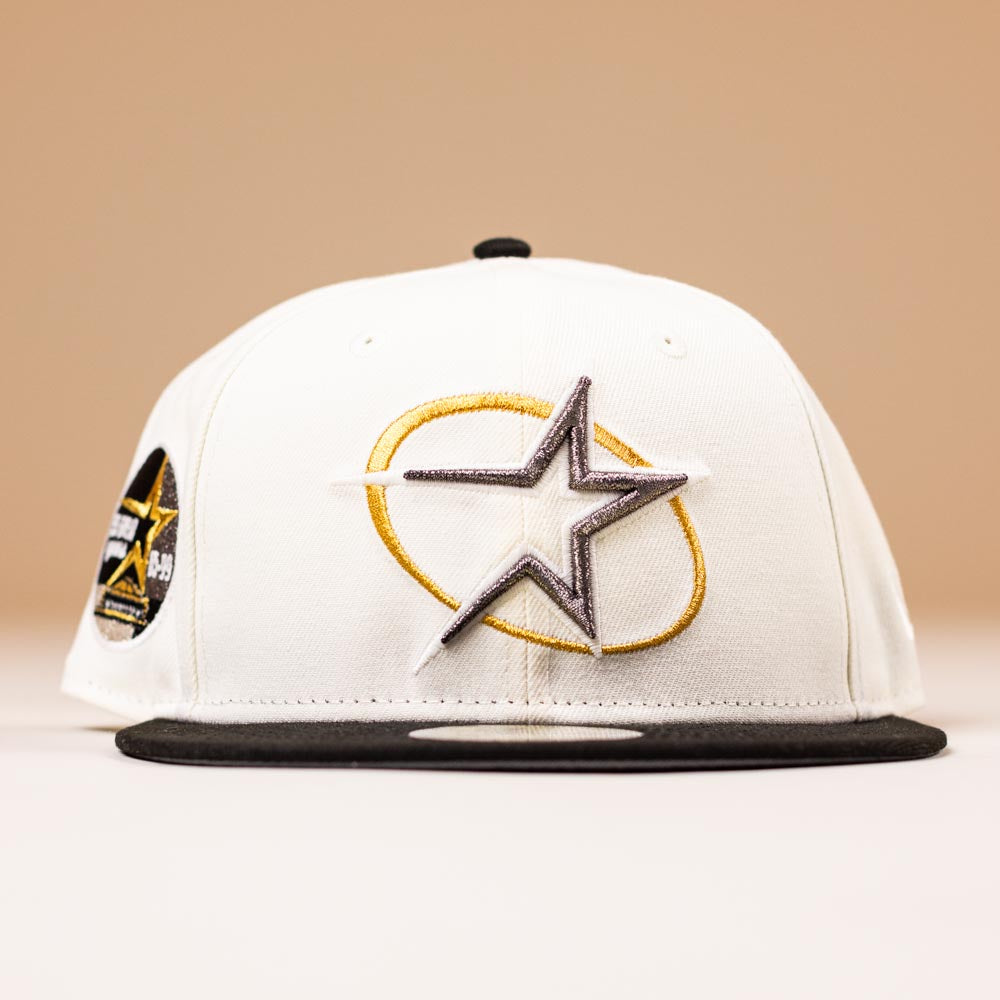 A White Black Circle Star Houston Astros New Era 5950 Fitted Hat, featuring a large embroidered star logo on the front and a black and gold patch on the left side, set against a neutral background.