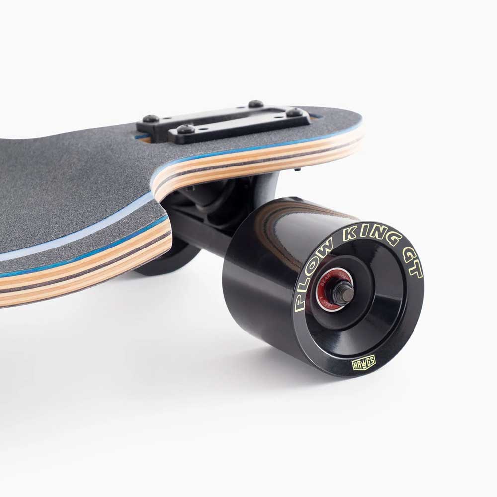 Close-up of the Atmosphere Switchblade 40 Landyachtz Complete Skateboard’s rear wheel and deck, showcasing its black FLOW KING GT wheel and layered wooden deck with grip tape.