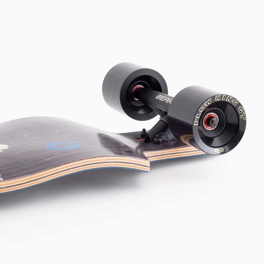 Close-up of the Atmosphere Switchblade 40 Landyachtz Complete Skateboard, featuring black FLOW KING GT wheels, robust trucks, and a wooden deck with visible layered edges against a white background.