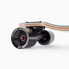 Close-up of the Atmosphere Switchblade 40 Landyachtz Complete Skateboard’s rear, showing black “PLOW KING GT” wheels and a multi-layered wooden deck with black and blue accents.