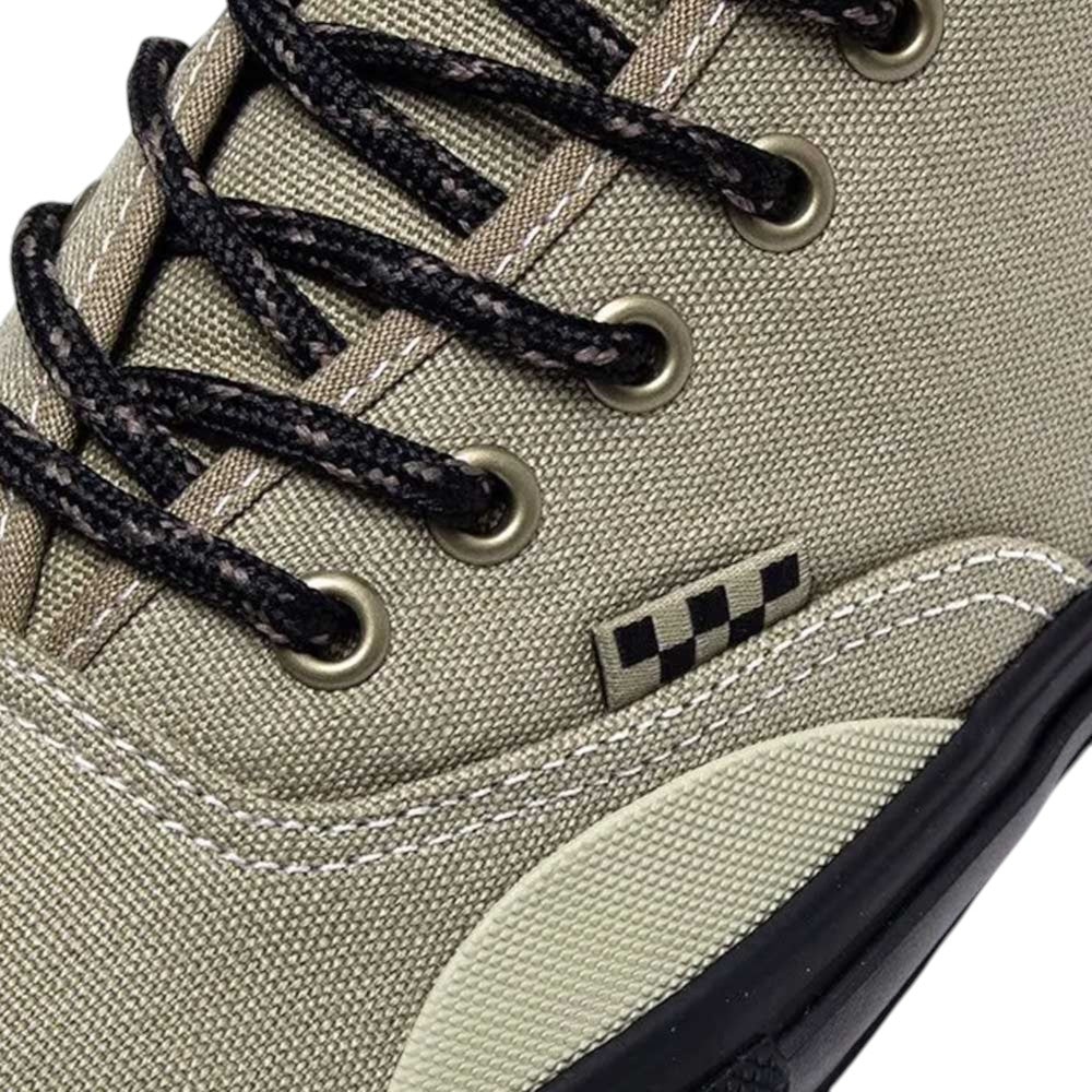 Close-up of the Vans Authentic High Elm Black VN000CBQEL7 skate shoe, featuring a tan canvas upper, black and white checkered tag, patterned black and white laces, and black metal eyelets.