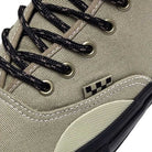 Close-up of the Vans Authentic High Elm Black VN000CBQEL7 skate shoe, featuring a tan canvas upper, black and white checkered tag, patterned black and white laces, and black metal eyelets.