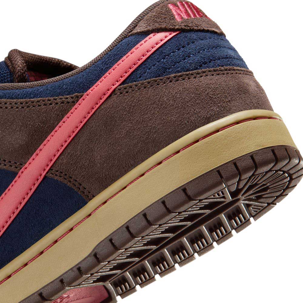 Close-up of the heel and sole of the Nike SB Dunk Low Pro HQ1625200, featuring Baroque Brown suede, Midnight Navy fabric, an Adobe pink stripe, and a tan textured rubber sole.