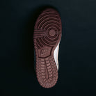 The image displays the bottom view of a single Ivory Sand Blue Void Dunk High Pro x Beyond IU4491100 Nike SB Skateboarding Shoe, highlighting its dark brown sole with a circular tread pattern and Nike logo, set against a solid black background.