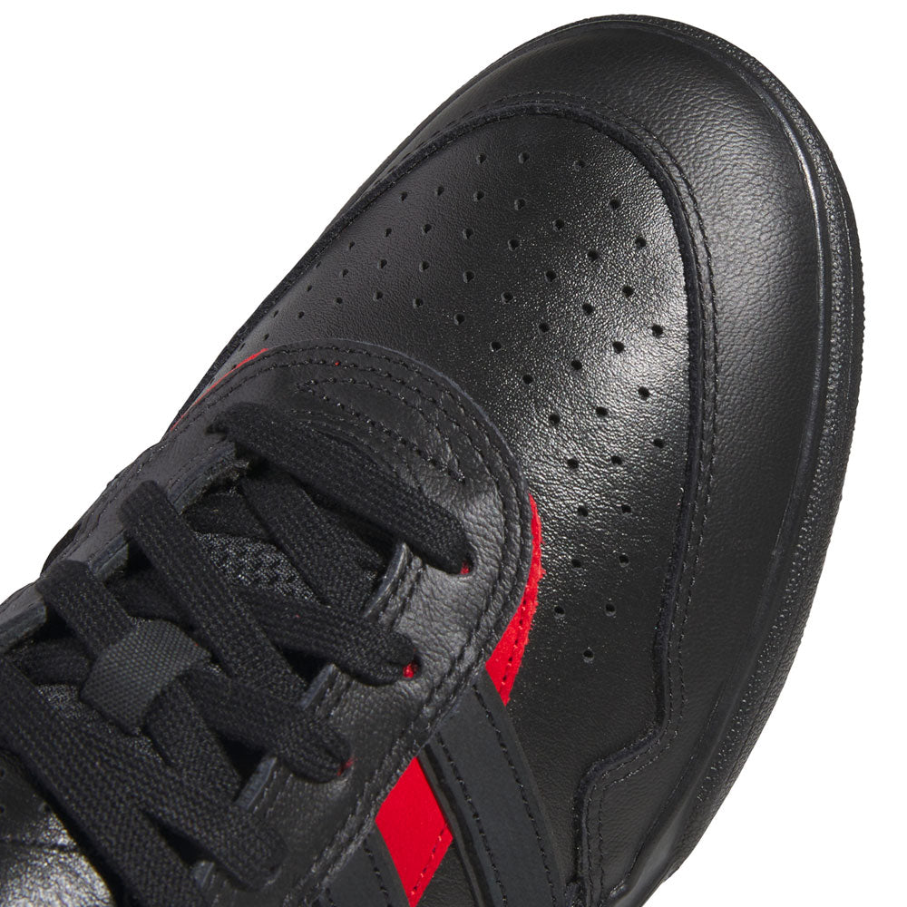 Close-up of a black sneaker with perforated detailing, black laces, and two red stripes on the side—these Black Black KK2981 Tyshawn II Suede Adidas Skateboarding Shoes are crafted for skaters, blending style and durability to elevate your everyday ride.