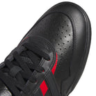 Close-up of a black sneaker with perforated detailing, black laces, and two red stripes on the side—these Black Black KK2981 Tyshawn II Suede Adidas Skateboarding Shoes are crafted for skaters, blending style and durability to elevate your everyday ride.