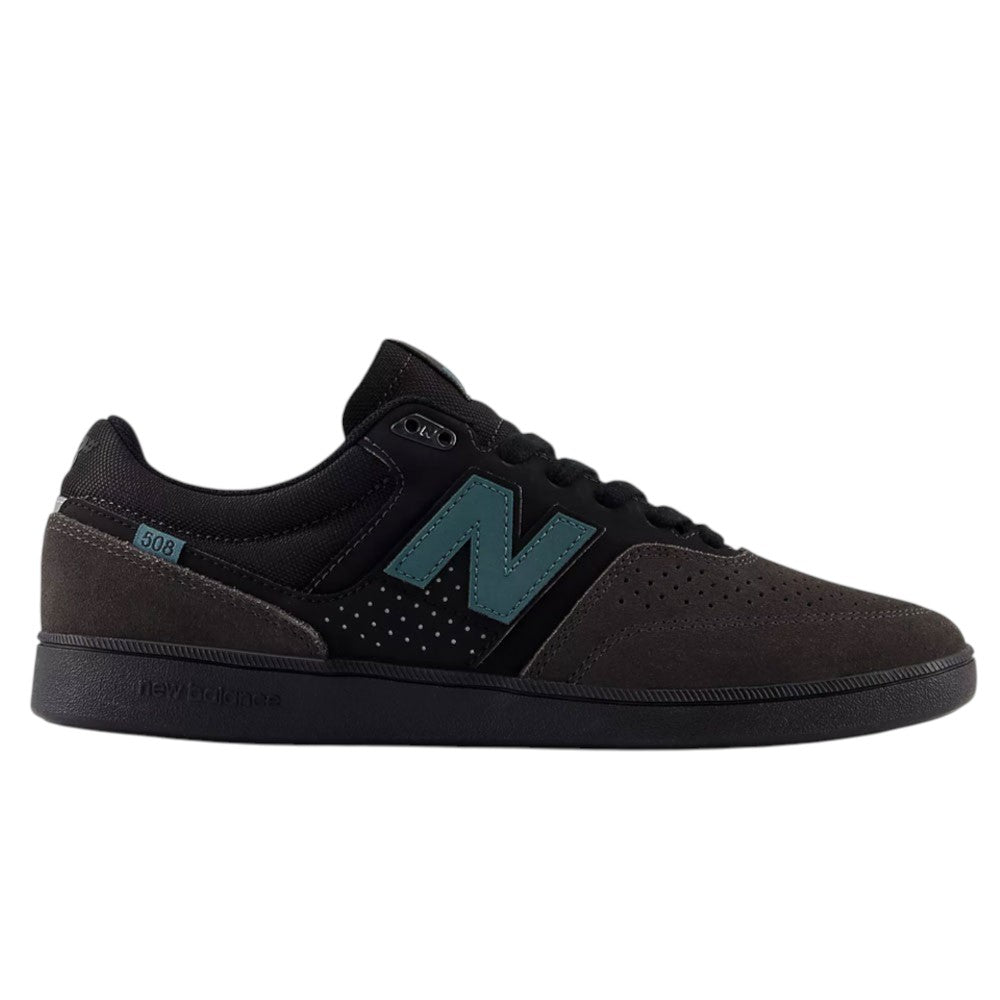 Introducing the Black Cement New Spruce 508 TAC New Balance Numeric Suede Skateboarding Shoes, featuring a black and dark gray design with a striking teal “N” logo on the side, black laces, and a perforated toe area—ideal for skate shoe enthusiasts and inspired by Brandon Westgate’s dynamic style.