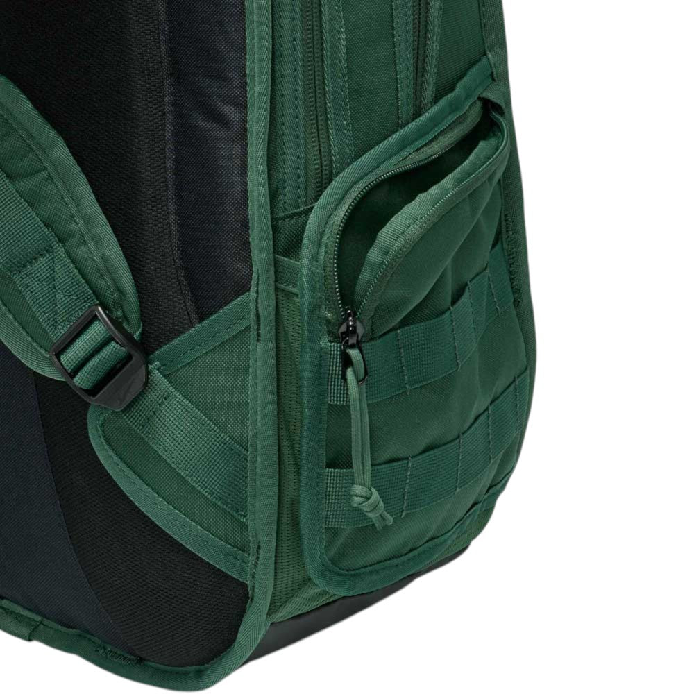 Close-up of the Black Fir FD7544323 Nike SB RPM Skate Backpack in green, highlighting its water-resistant material, partially unzipped front pocket, webbed design, and padded strap against a white background.