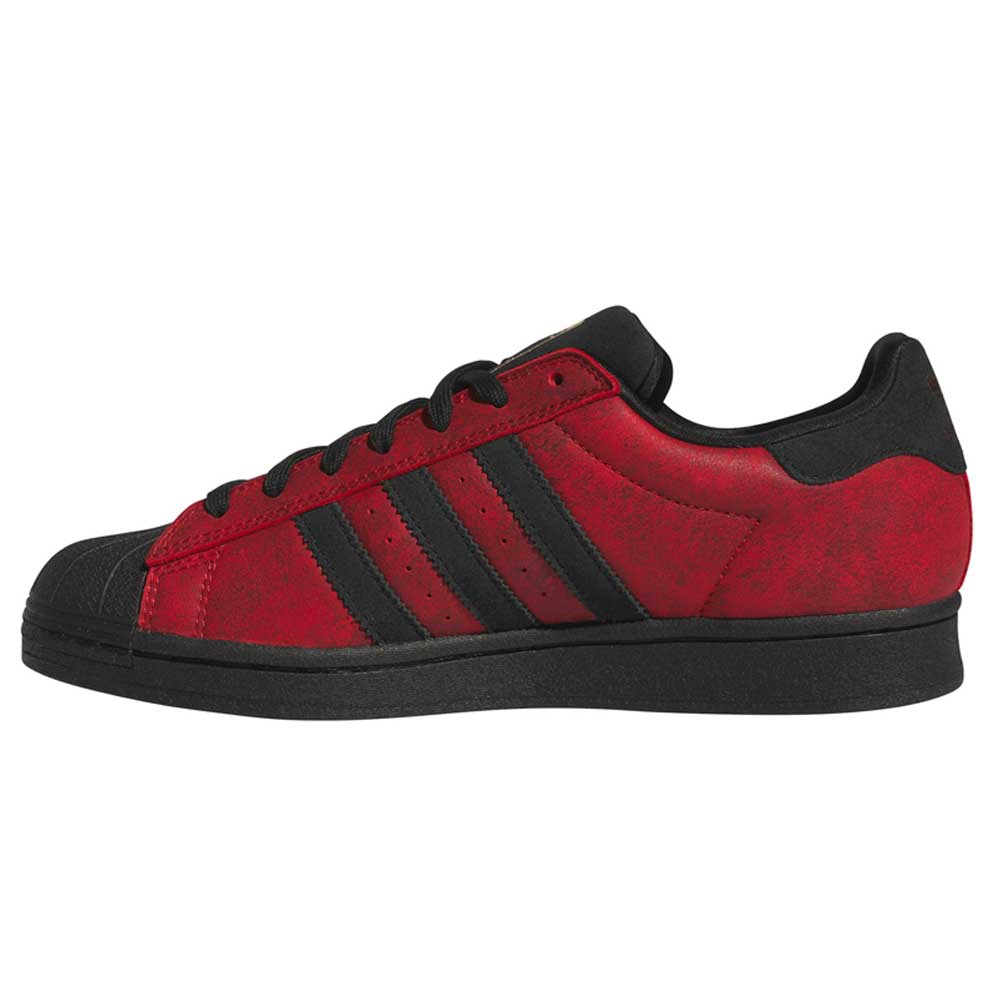 A low-top skateboarding shoe from adidas, the Black Red Fog KJ5118 Superstar Adidas Skateboarding Suede Shoes Footwear features a red and black color scheme with three black stripes on the side, a black toe cap, and a black sole, all as seen from the side.