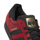Close-up of the Black Red Fog KJ5118 Superstar Adidas Skateboarding Suede Shoe, featuring a gold tongue label, black laces, and SUPERSTAR written in gold on the side—perfect for fans of adidas skateboarding footwear.