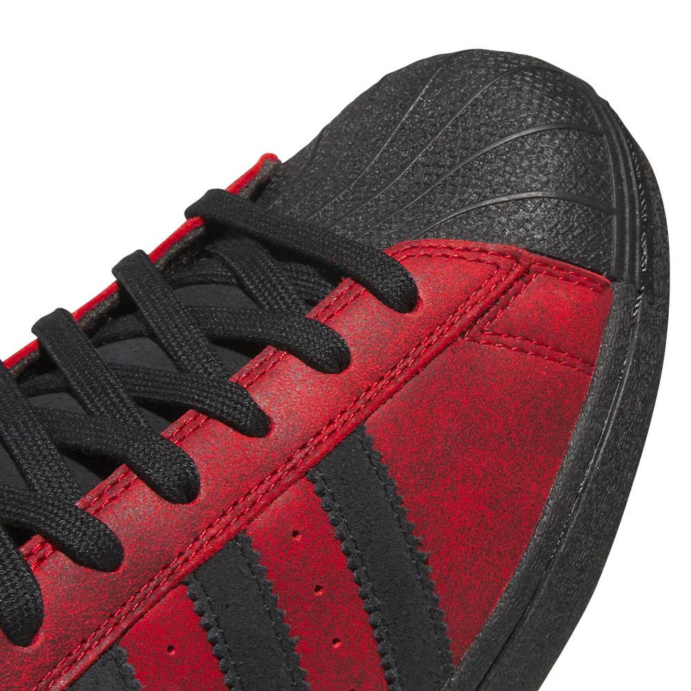 Close-up of the Black Red Fog KJ5118 Superstar Adidas Skateboarding Suede Shoes Footwear, featuring a bold red and black colorway with black laces, a textured black toe cap, and signature black stripes on the side—highlighting the classic skateboarding-ready design.