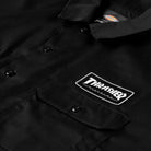Close-up of the Black Work Shirt Thrasher Magazine x Dickies Skateboarding A88HT BLK, a relaxed fit short sleeve shirt with a “Thrasher” patch above the chest pocket and a Dickies logo on the collar.