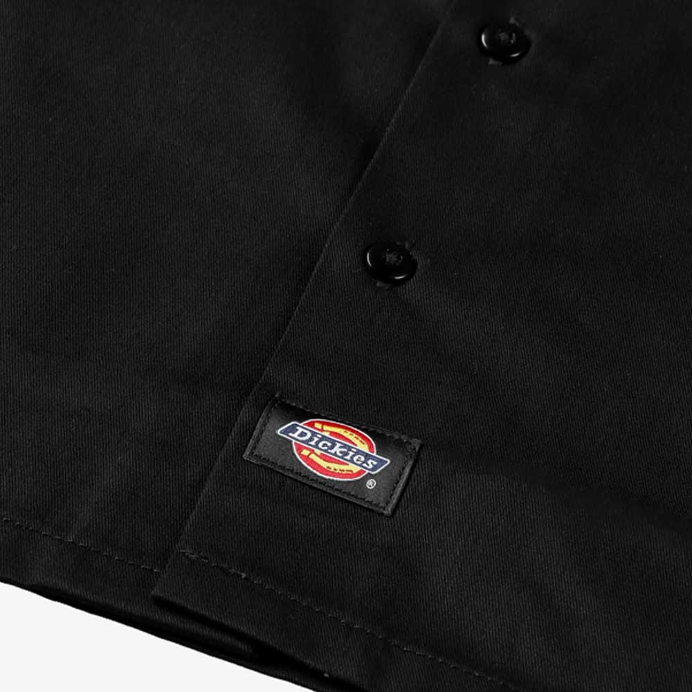 Close-up of the Black Work Shirt Thrasher Magazine x Dickies Skateboarding A88HT BLK, a relaxed fit short sleeve shirt with black buttons and a stitched co-branded logo patch near the hem.