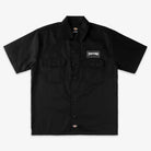 The Black Work Shirt Thrasher Magazine x Dickies Skateboarding A88HT BLK features a relaxed fit, short sleeves, dual chest pockets, a white Thrasher logo patch on the left pocket, and a small Dickies tag. Part of their exclusive skate collection.