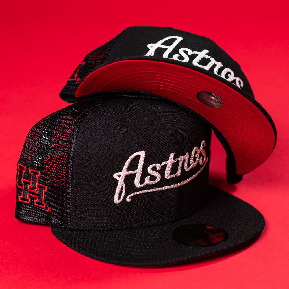Two Black Scarlet Trucker Houston Cougars New Era Hat 5950 Fitted caps by New Era, featuring white Astros embroidery on the front, red underbrims, and a red H logo on the side, are displayed against a bold red background.