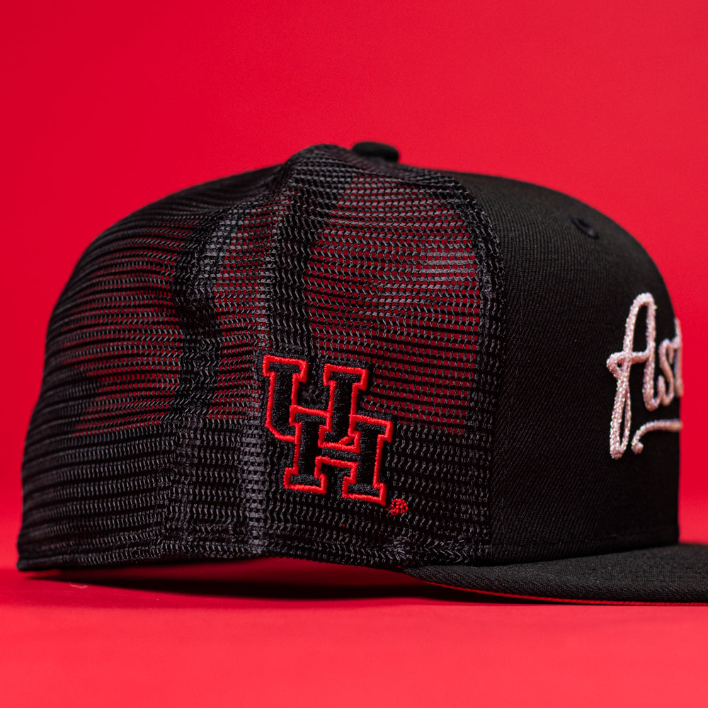 The Black Scarlet Trucker Houston Cougars New Era Hat 5950 Fitted features a black mesh design, red UH embroidery on the side, and white script on the front—perfect for any Houston Cougars fan.