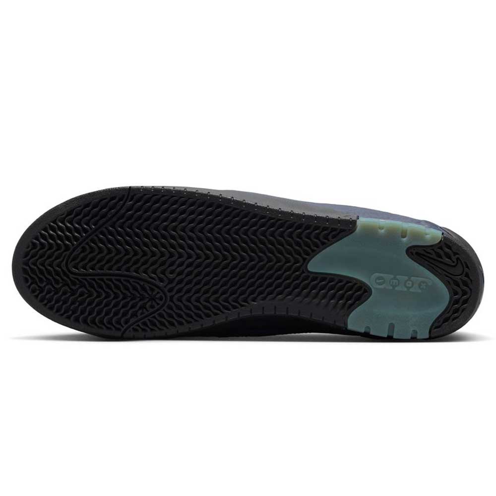 The image shows the black rubber outsole of the Blue Void Metallic Silver IR1887400 Air MAX Ishod Nike SB skateboarding shoes, featuring a wavy tread pattern and a blue-green heel accent that highlights its Max Air cushioning.