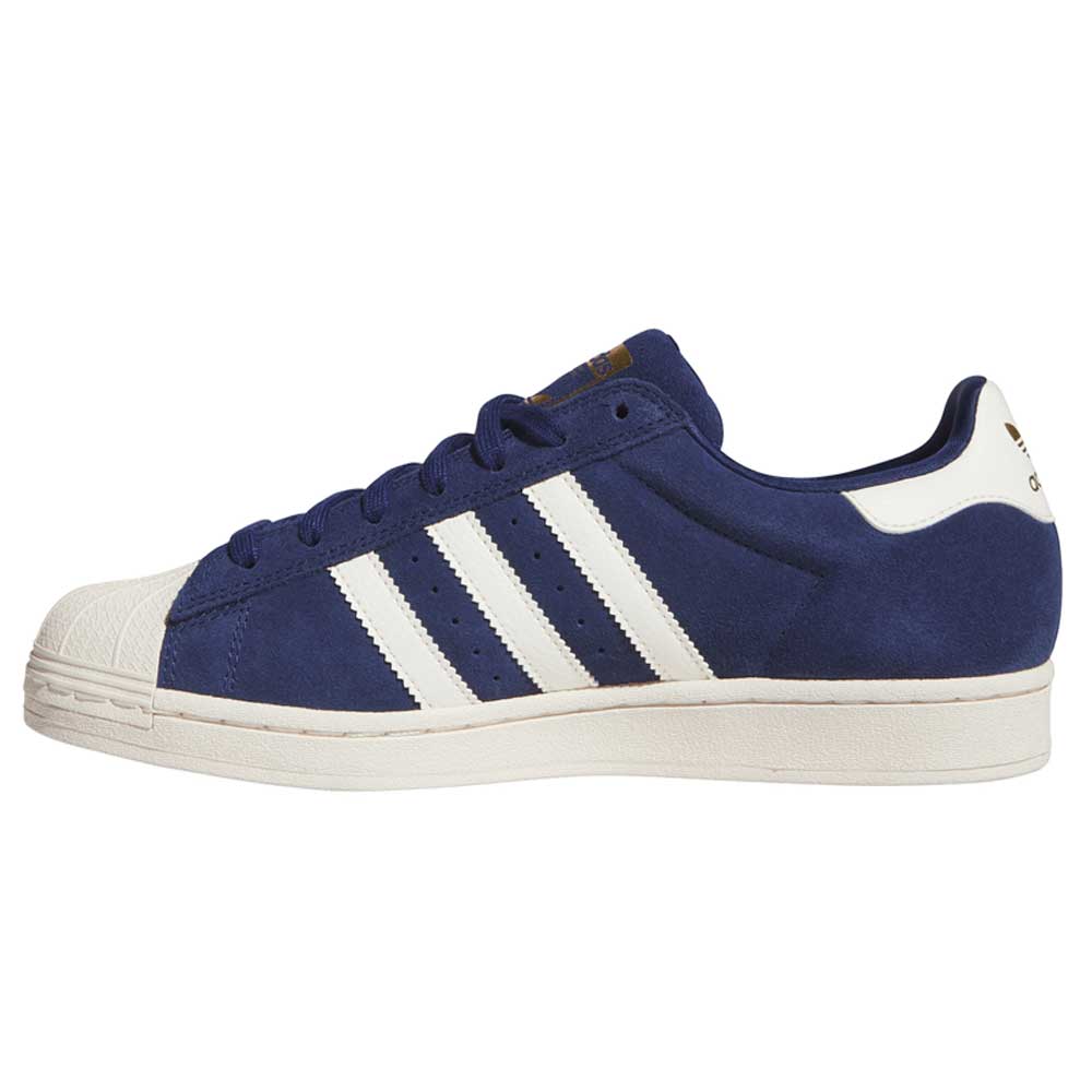A navy blue Adidas Blue White KJ5113 Superstar Skateboarding Suede Shoe, featuring iconic white stripes, a white heel tab, and a textured off-white sole, is shown in a side view against a white background. Part of the Superstar ADV line and inspired by classic skate shoes, this footwear blends elevated style with performance.