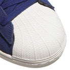 Close-up of the toe area of the Blue White KJ5113 Superstar Adidas Skateboarding Suede Shoes, showcasing a textured white rubber shell and dark blue suede upper with matching laces—ideal for skateboarding footwear enthusiasts.