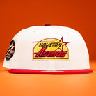 A Poppa Burger Bo Bundy 35th Houston Astros Bo New Era Hat 5950 Fitted in white with a red brim and a yellow, red, and purple logo is shown against an orange background.