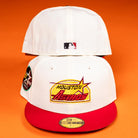 Two Poppa Burger Bo Bundy 35th Houston Astros New Era 5950 Fitted hats are displayed on an orange background. The front hat shows the Astros logo, and the back features the MLB logo, with official stickers and special patches on both.