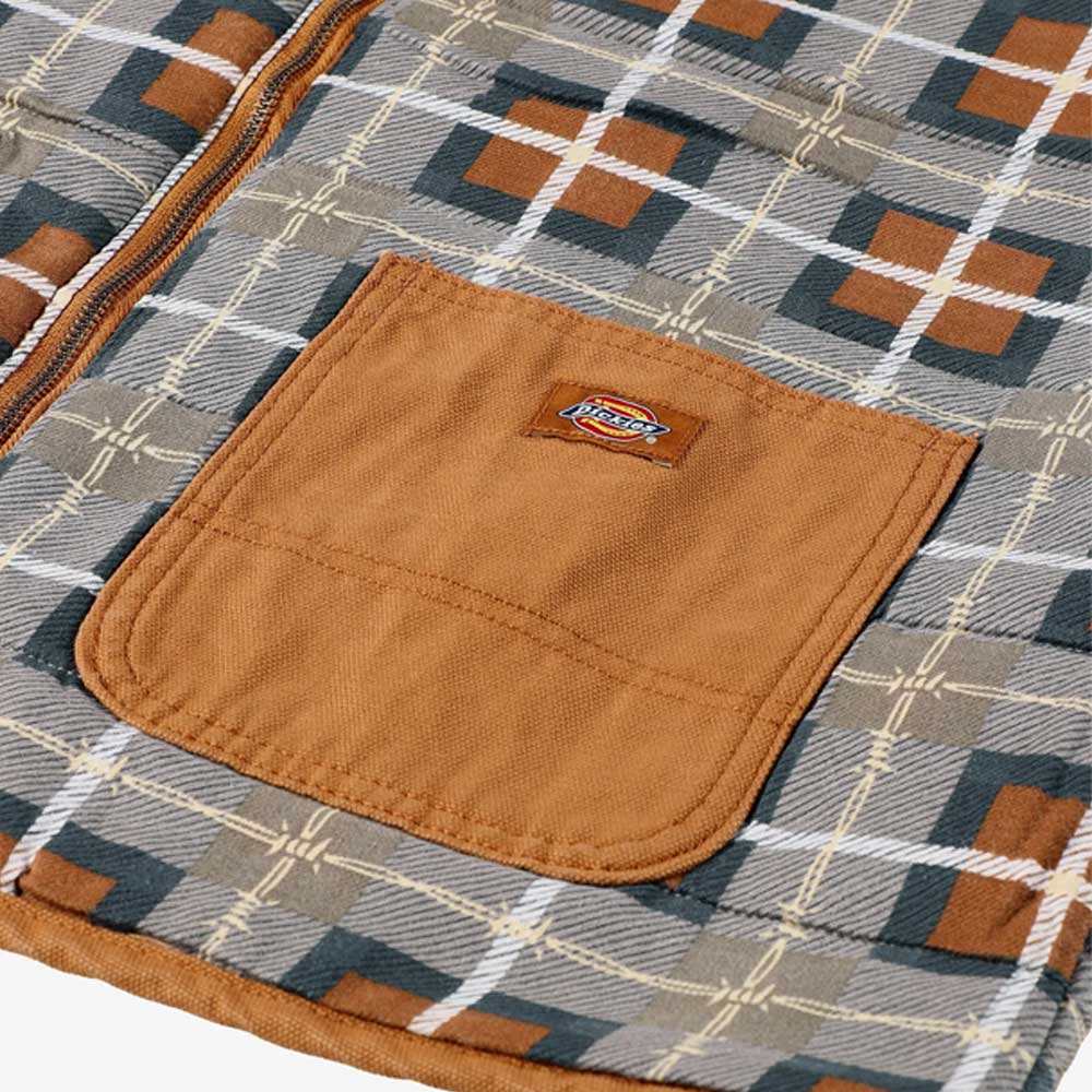 Close-up of a geometric brown, gray, and white fabric with a brown pocket featuring a small Dickies logo patch—part of the Brown Duck Vest Thrasher Magazine x Dickies Skateboarding A88IT 0BD.