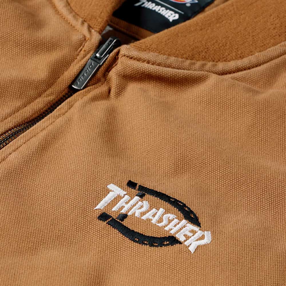 Close-up of the Brown Duck Vest Thrasher Magazine x Dickies Skateboarding A88IT 0BD, featuring a YKK zipper, Thrasher logo with a black stitched circular design, textured fabric, and a relaxed, street-ready fit.
