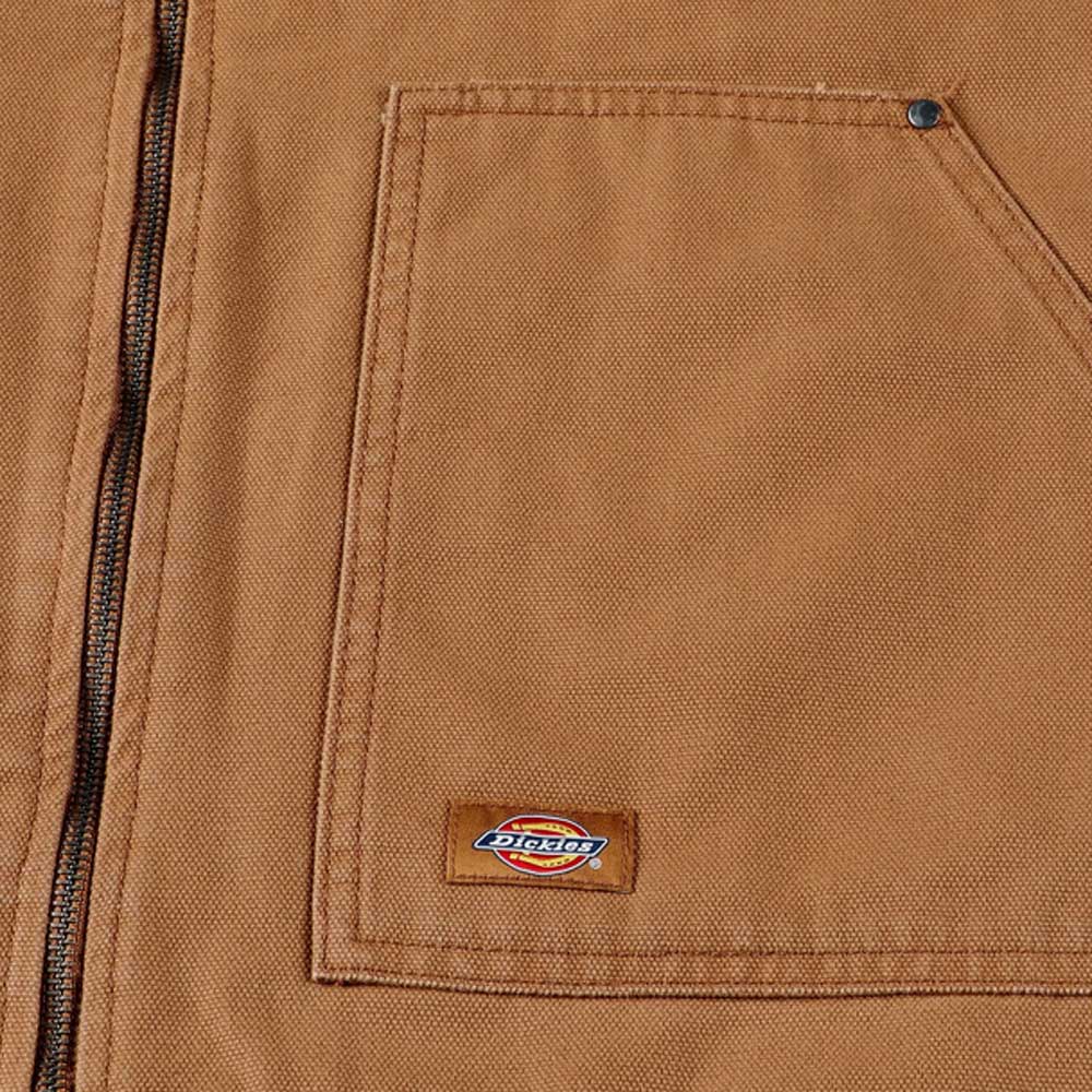Close-up of the Brown Duck Vest Thrasher Magazine x Dickies Skateboarding A88IT 0BD, featuring a brown canvas build, large front pocket with zipper, and a small rectangular Dickies logo patch, highlighting its relaxed fit.