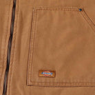 Close-up of the Brown Duck Vest Thrasher Magazine x Dickies Skateboarding A88IT 0BD, featuring a brown canvas build, large front pocket with zipper, and a small rectangular Dickies logo patch, highlighting its relaxed fit.