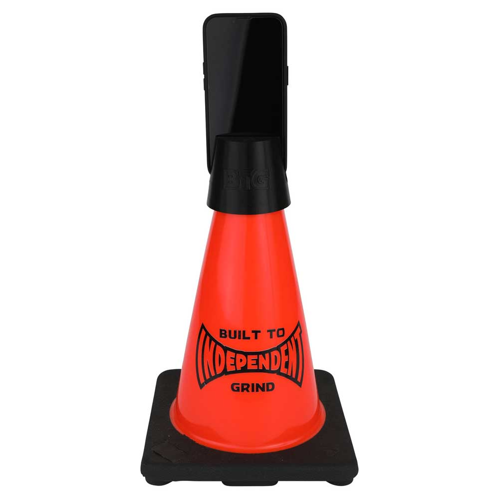 The Built to Grind Independent Phone Cone, inspired by the iconic Independent Trucks mantra and featuring “BUILT TO INDEPENDENT GRIND” printed on its orange surface, securely holds a black smartphone vertically at the top. This distinctive accessory serves as both a phone stand and a sturdy display piece with its solid black base.