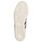 The image shows the sole of the Busenitz Tan White Black HQ4746 Adidas Skateboarding Suede Shoes, with a textured rubber pattern and Adidas logo. The light sole contrasts with part of the black durable suede upper along the sides.