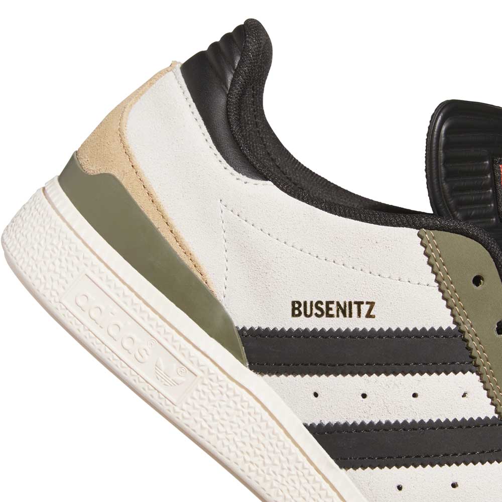 Close-up of the Busenitz Tan White Black HQ4746 Adidas Skateboarding Suede Shoe featuring white suede, black stripes, olive and beige accents, a textured white sole, black padded heel, and gold BUSENITZ lettering above the stripes.