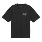 The Caballero VN000XHBBLK1 Black Tee from Vans Skateboarding is a loose fit, black short-sleeve T-shirt featuring a small white dragon graphic and text on the left chest, shown laid flat on a white background.