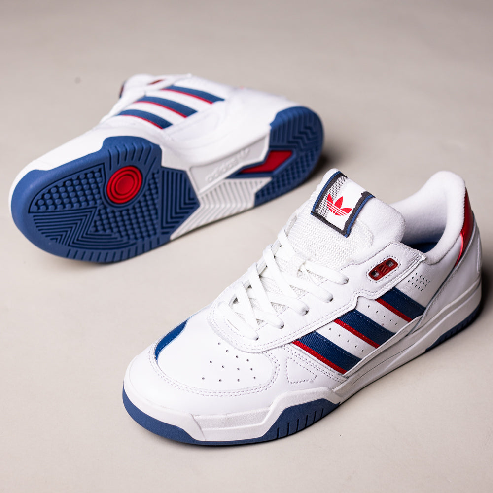 A pair of White Brown Tekkira HQ4814 Adidas Skateboarding suede leather shoes; one stands upright, the other lies on its side, showcasing the blue sole, signature three stripes, and Lightmotion cushioning for comfort.