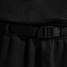 Close-up of a person wearing the Ishod Cargo Pant Sweatpant Black IF0659010 Nike SB with an elastic waistband and black plastic buckle belt, paired with a black perforated top.