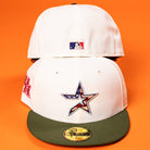 Two white Stars Over Houston UH New Era Hat 5950 Fitted hats are shown on an orange background. The front cap displays a star logo with an American flag design and a green brim; the back shows a small MLB logo.
