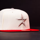 Introducing The Carter Chrome Scarlet Houston Cougars New Era Hat 5950 Fitted: a striking white fitted cap featuring a bold red brim and an eye-catching silver star logo embroidered on the front, showcased against a sleek black background—an ideal choice for Houston Cougars fans aiming to enhance their game day look.