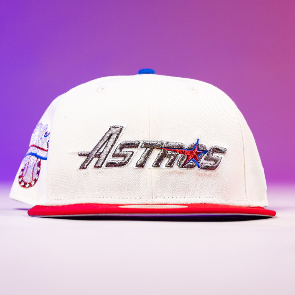 The Diplomat Chrome Scarlet Houston Astros New Era Hat 5950 Fitted features a white crown, metallic silver Astros embroidery with a star on the front, red brim, blue top button, and is shown on a pink-purple gradient background.