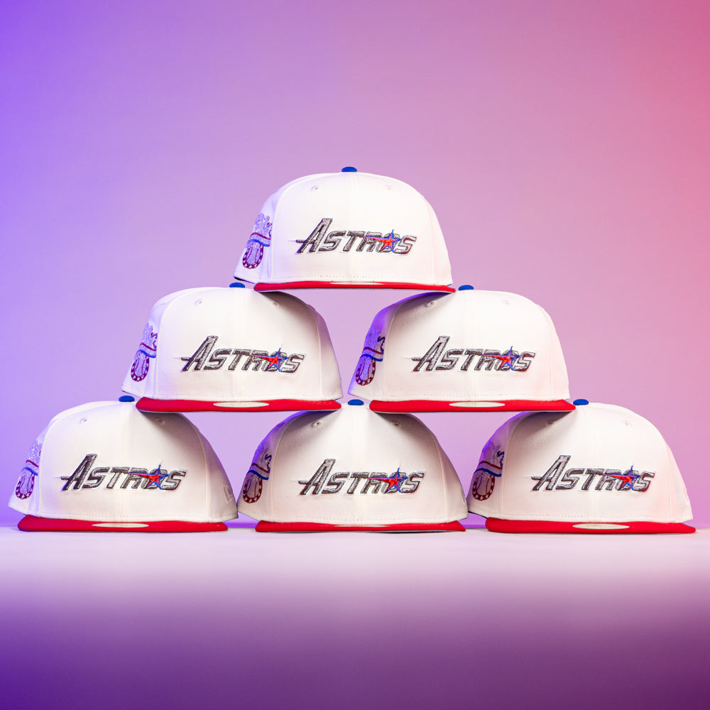 Six The Diplomat Chrome Scarlet Houston Astros New Era Hat 5950 Fitted caps by New Era, with red brims and chrome accents, are arranged in a pyramid against a pink-purple gradient background, each showcasing the Astros logo on the front.