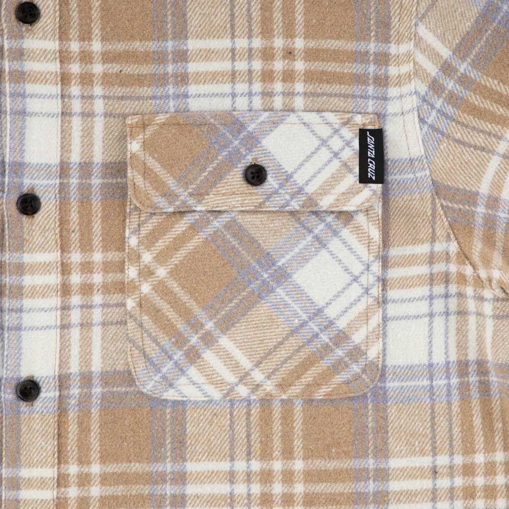 Close-up of the Classic Lonsleeve Flannel Top Sand Plaid by Santa Cruz, featuring a buttoned front pocket with a brand tag and showcasing the soft checkered fabric—iconic men's long-sleeve skateboard apparel.