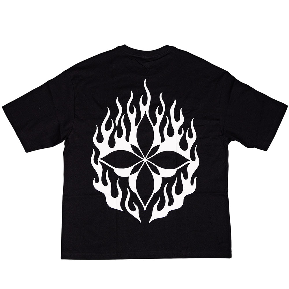 The Cleo Flame Black Tee features a large white graphic of a stylized flower surrounded by flame shapes on the back, and is crafted from premium materials in a cut-and-sew construction for superior comfort and quality.