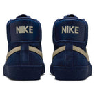 A pair of Coastal Blue Pale Yellow IO0667400 Blazer Mid Nike SB suede skateboarding shoes seen from the back, featuring pale yellow swooshes and NIKE in bold white on the heel tabs, designed for responsive cushioning and all-day comfort.