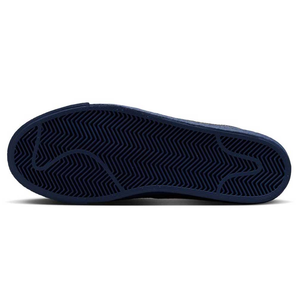The image shows the dark blue sole of the Coastal Blue Pale Yellow IO0667400 Blazer Mid Nike SB Suede Skateboarding Shoes, featuring a zigzag herringbone tread and curved lines for grip, traction, and responsive cushioning—ideal for skateboarding.