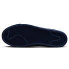 The image shows the dark blue sole of the Coastal Blue Pale Yellow IO0667400 Blazer Mid Nike SB Suede Skateboarding Shoes, featuring a zigzag herringbone tread and curved lines for grip, traction, and responsive cushioning—ideal for skateboarding.