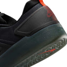 Close-up of the heel on the Cool Grey White FQ1273-003 Zoom Nyjah 4 Nike SB Skateboarding Shoe, featuring a reinforced mesh upper, dark grey sole, and bold red Nike logo on the heel counter for standout style and durability.