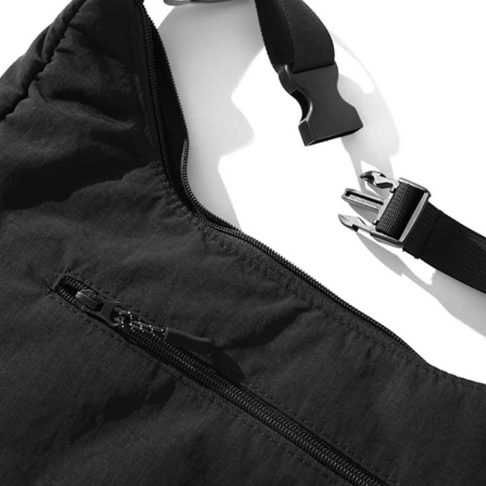 Close-up of the Crossbody Bag Black Butter Goods in black ripstop, featuring a zippered pocket and adjustable shoulder strap with plastic side-release buckle, photographed on a white background.