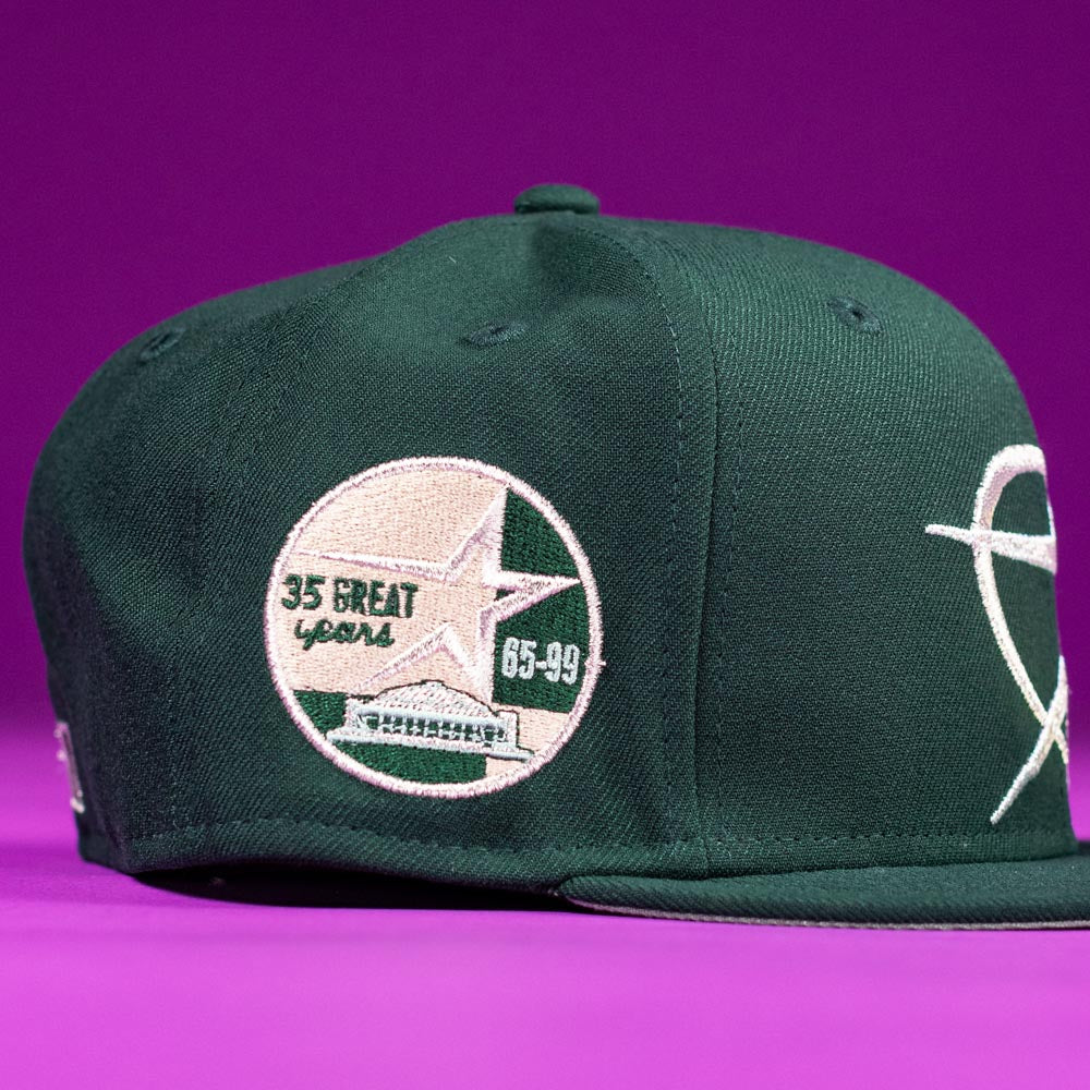The Merc Green Silver 35th Houston Astros New Era Hat 5950 Fitted features a dark green design with a round embroidered "35 Great Years 65-99" patch and star, perfect for fans and collectors.
