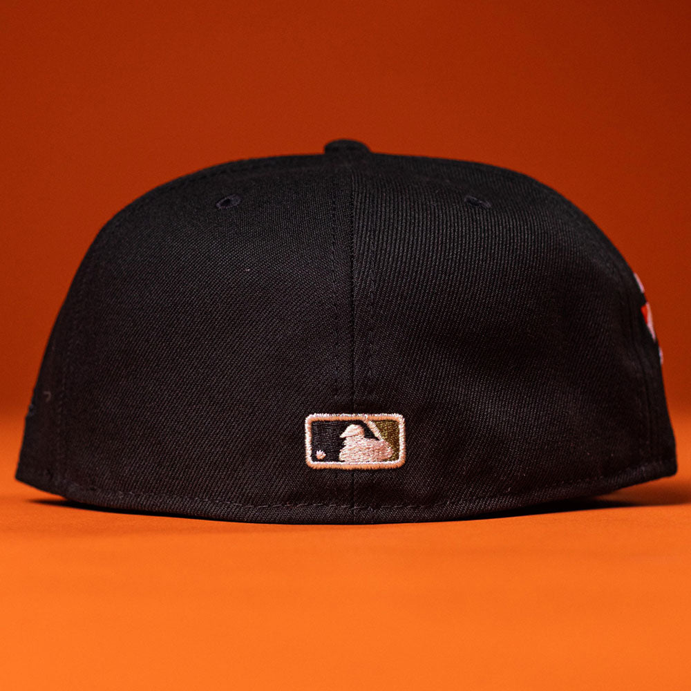 A Daikin Park Olive Houston Astros New Era 5950 Fitted Hat is shown upside down on an orange surface, with the back featuring an embroidered MLB logo.