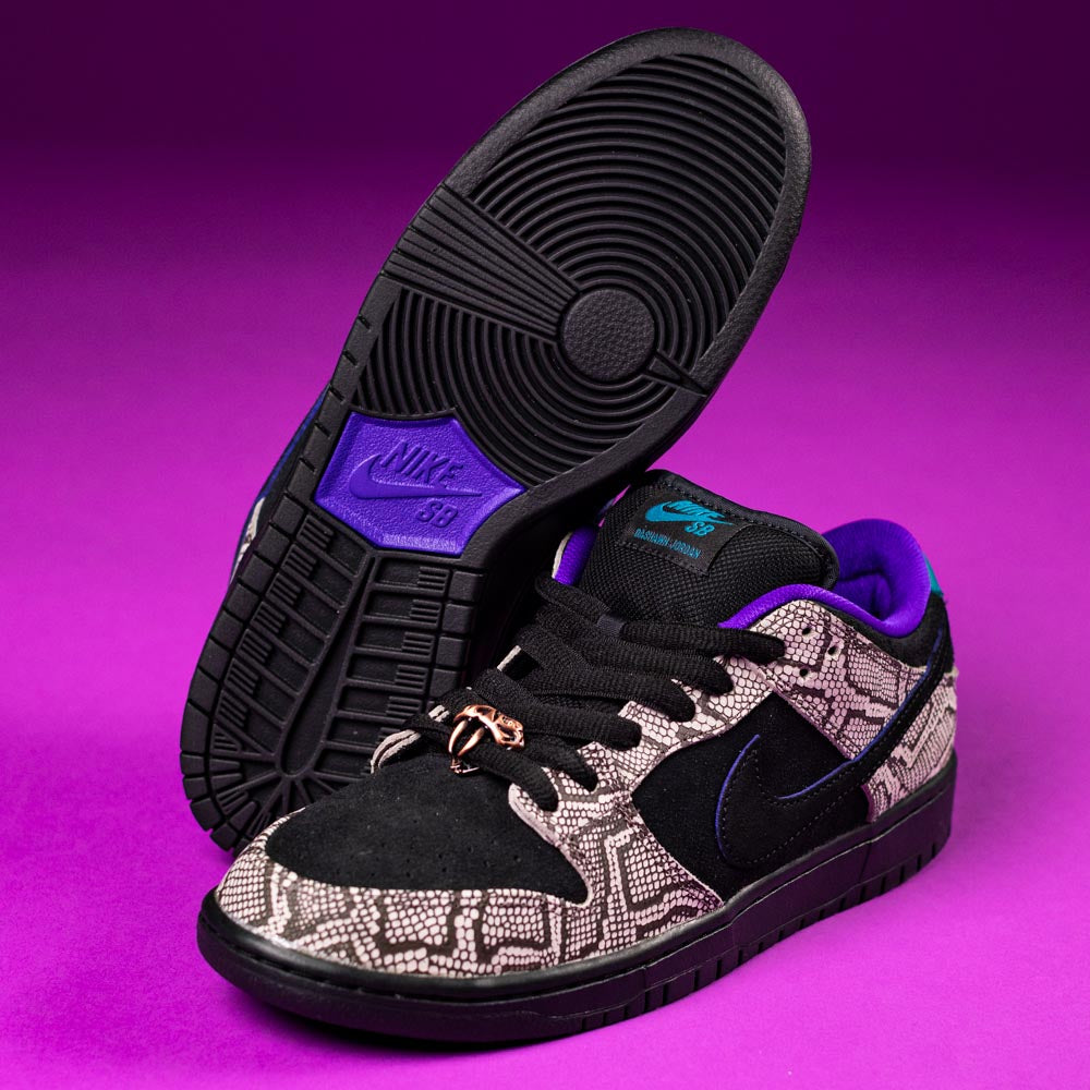 The READ BELOW the BUTTON RAFFLE Nike SB Dashawn Jordan Dunk Low, featuring black soles, black suede and textured gray overlays, purple lining, blue accents, and a gold lace charm, is displayed on a purple background for Southside Skatepark's raffle.