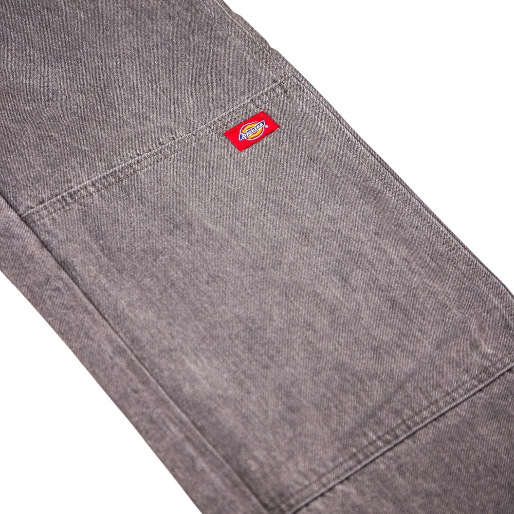 A close-up of the Loose Straight Grey Wash Tinted L22 A88H4 Double Knee Jean Denim Pant by Dickies Skateboarding shows a rectangular pocket and a small red Dickies label sewn onto it.
